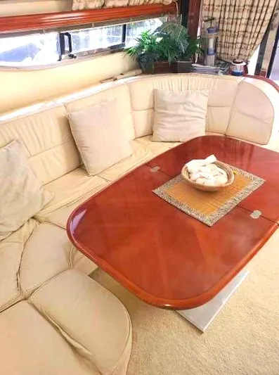  Yacht Photos Pics Luxurious interior of a 1998 Viking Sports Cruiser with plush seating and elegant wooden table.