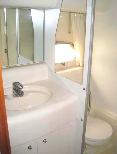  Yacht Photos Pics Bathroom interior of a 1998 Viking Sports Cruiser with sink, mirror, and toilet.