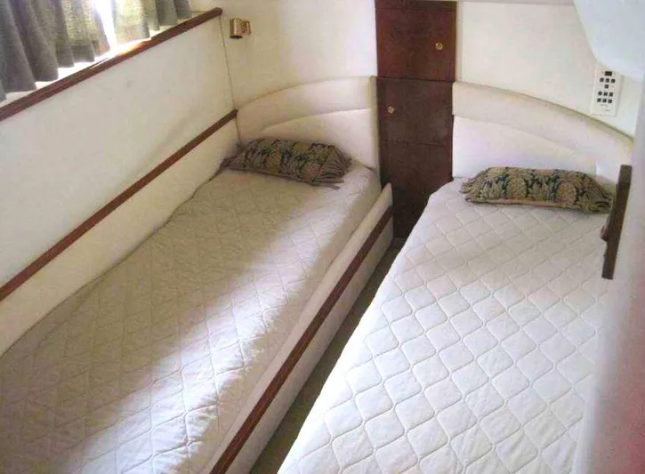  Yacht Photos Pics Twin beds in 1998 Viking Sports Cruiser cabin, featuring white bedding and decorative pillows.
