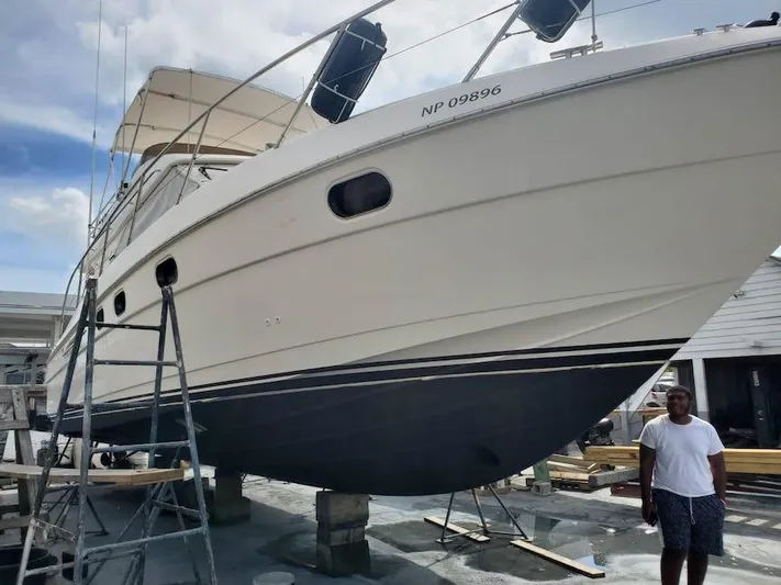  Yacht Photos Pics 1998 Viking Sports Cruiser on dry dock with a ladder and a person nearby.
