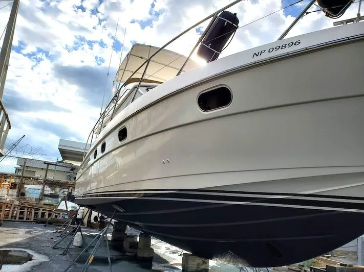  Yacht Photos Pics 1998 Viking Sports Cruiser yacht on dry dock under a cloudy sky.