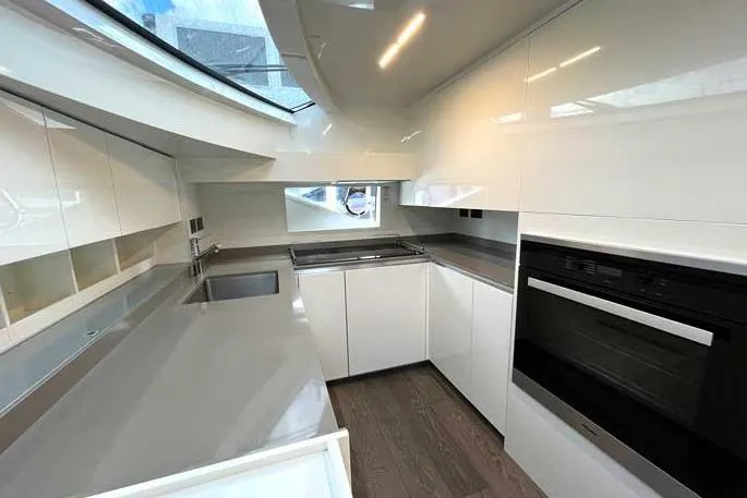  Yacht Photos Pics Modern kitchen interior on 2020 Ferretti Yachts 850, featuring sleek white cabinetry and appliances.