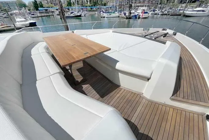  Yacht Photos Pics Luxurious seating area on 2020 Ferretti Yachts 850 with wooden table and marina view.