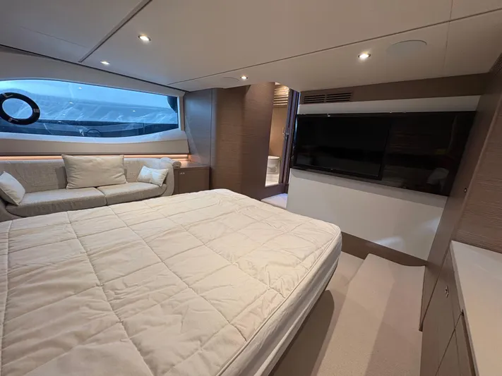  Yacht Photos Pics Luxurious 2025 Princess V55 yacht bedroom with modern decor and large window view.