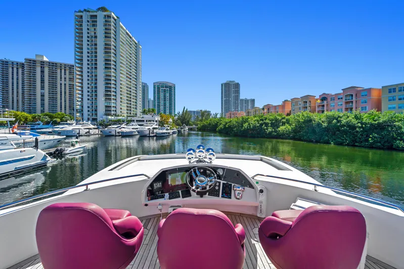  Yacht Photos Pics Luxurious 2013 Sunseeker Predator 84 yacht with vibrant seating, docked in a scenic marina.