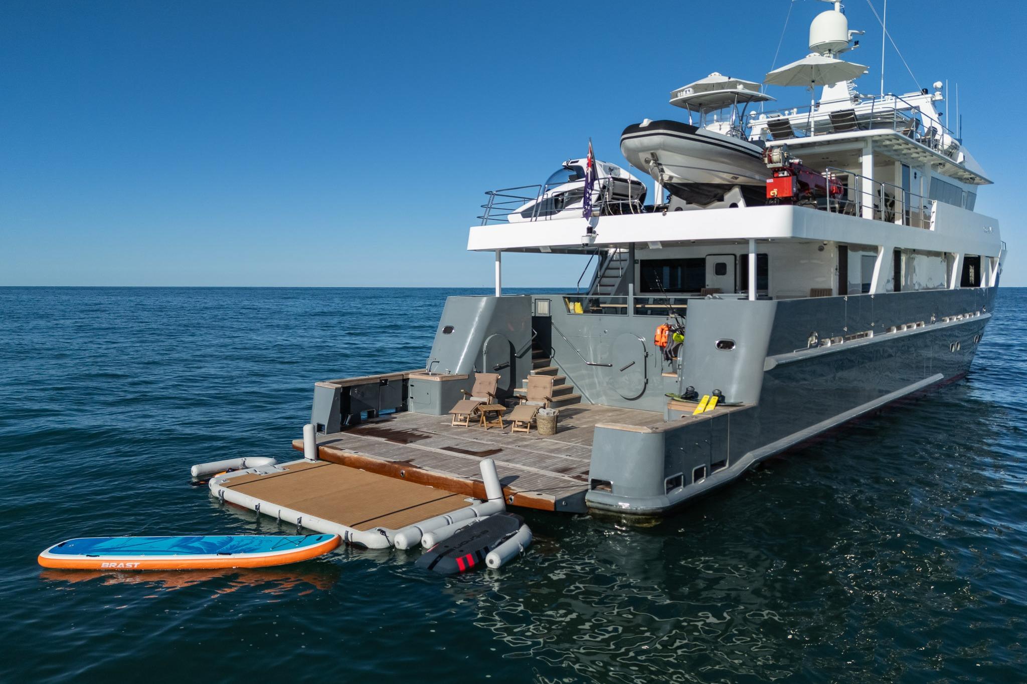 2005 Tenix Defence ICE Explorer yacht with paddleboard on calm ocean waters.