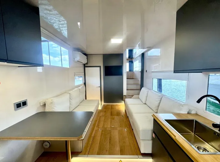  Yacht Photos Pics Modern Navisyo Homes NV.08 interior with sleek design, featuring sofas, table, and kitchenette, 2022 model.