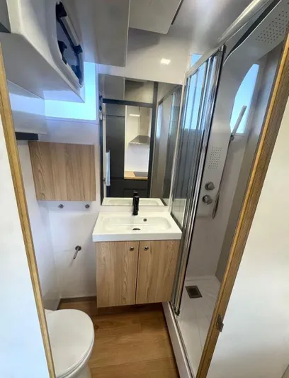  Yacht Photos Pics Modern bathroom in 2022 Navisyo Homes NV.08 with shower, sink, and wooden cabinetry.