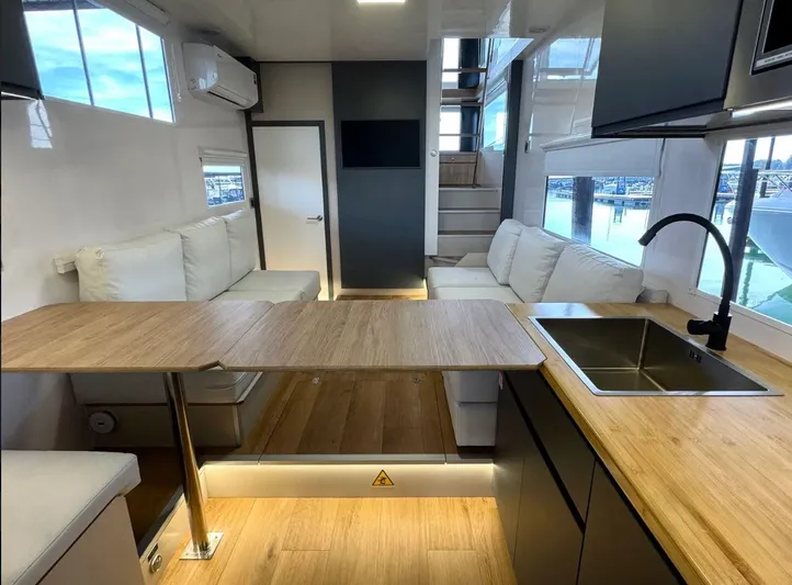  Yacht Photos Pics Modern interior of 2022 Navisyo Homes NV.08 with wooden countertops and white seating.