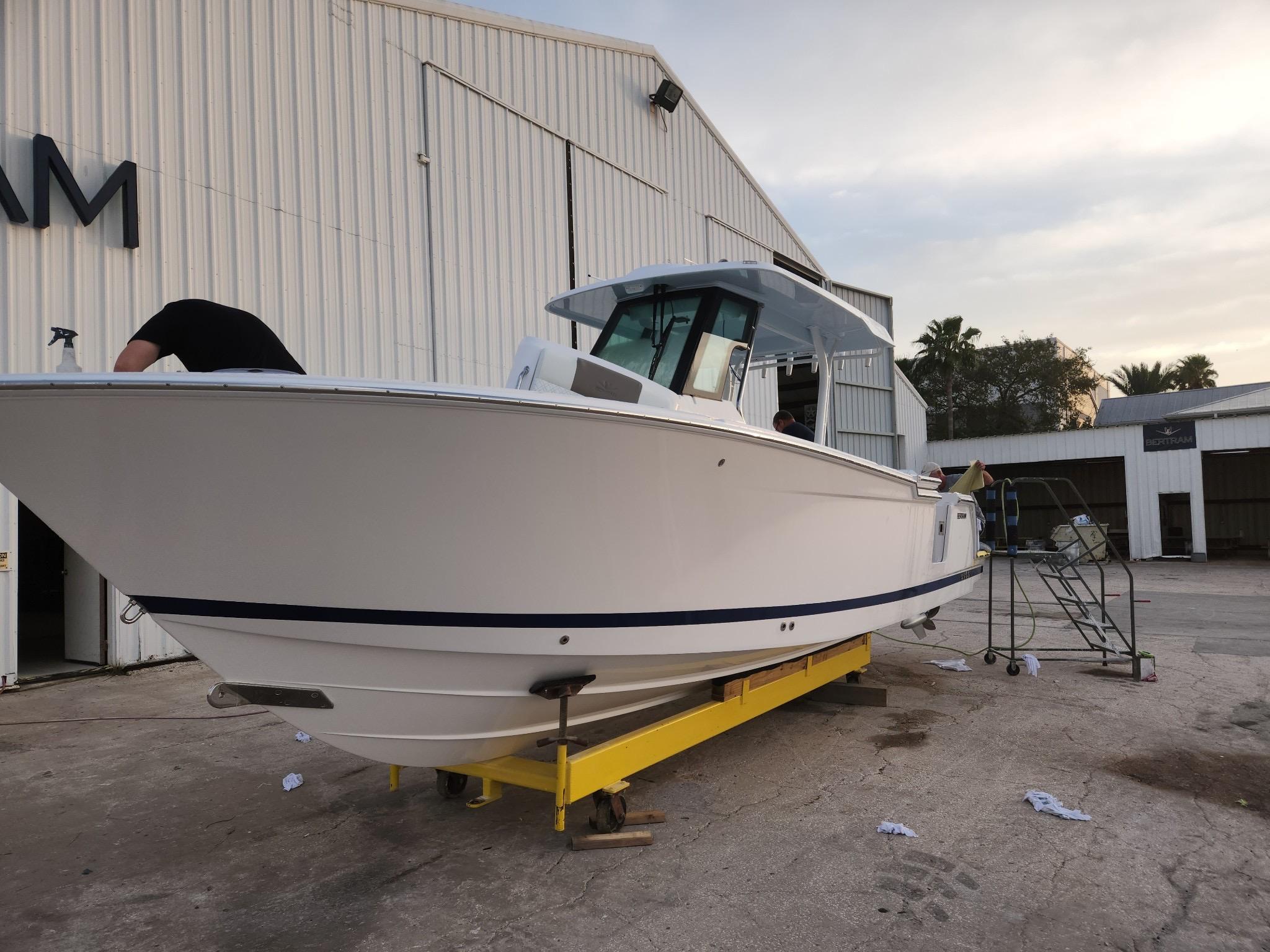 2023 Bertram 28 CC boat on a yellow trailer outside a warehouse.