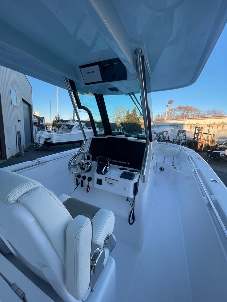 2023 Bertram 28 CC center console boat with modern helm and white seating.