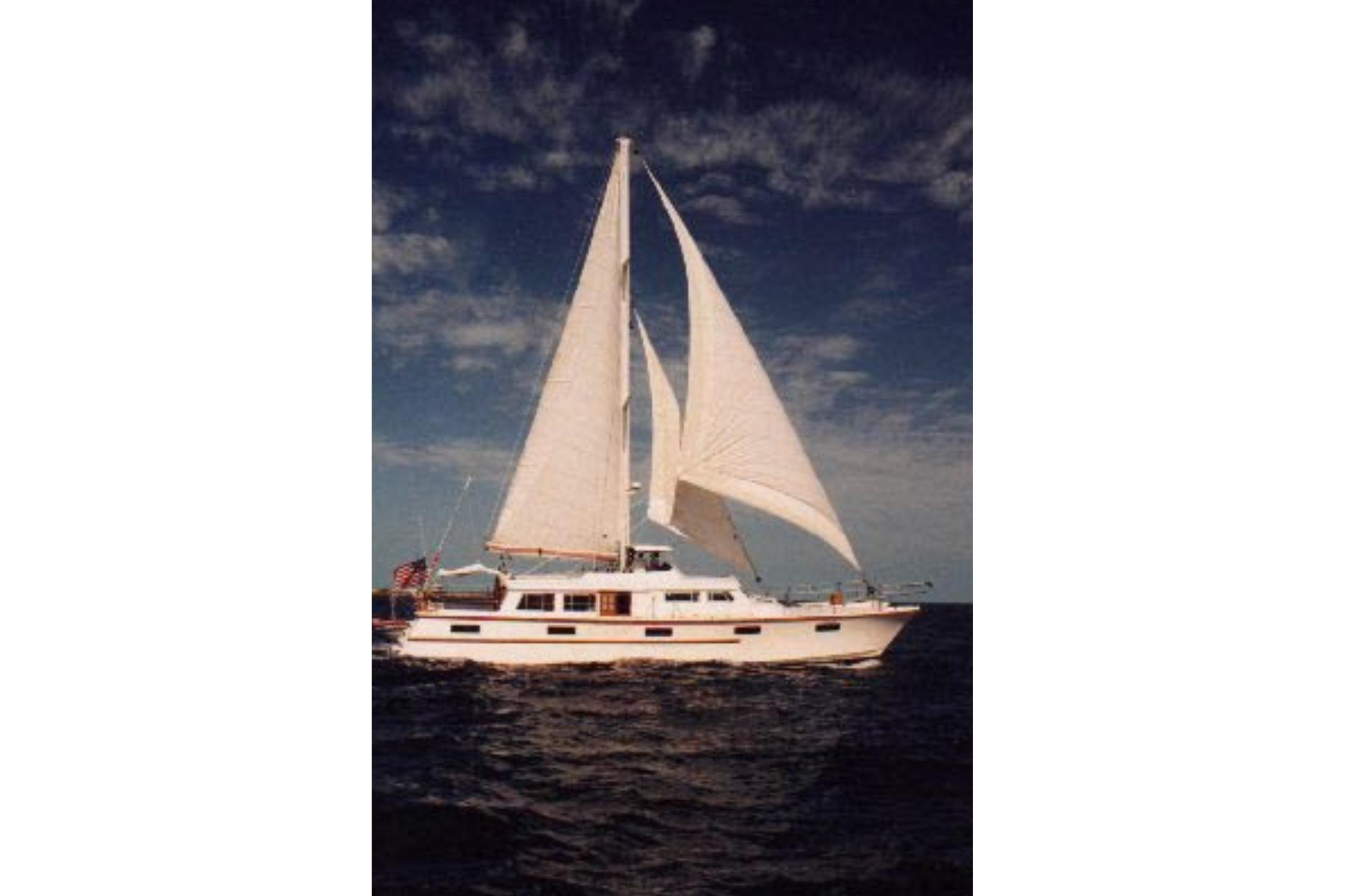 Sailing yacht on open sea, Custom model 60, 1985, under clear sky.