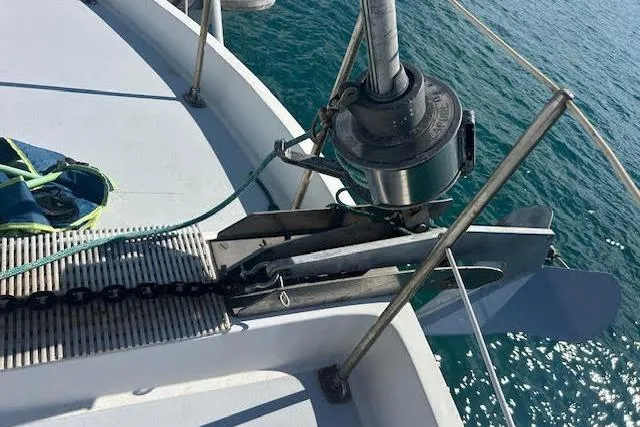 Liahona Yacht Photos Pics Anchor system on a 1985 Custom 60 boat, with chain and winch, over blue water.