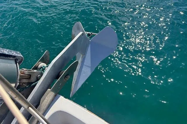 Liahona Yacht Photos Pics Anchor of a 1985 Custom 60 boat submerged in clear blue water.