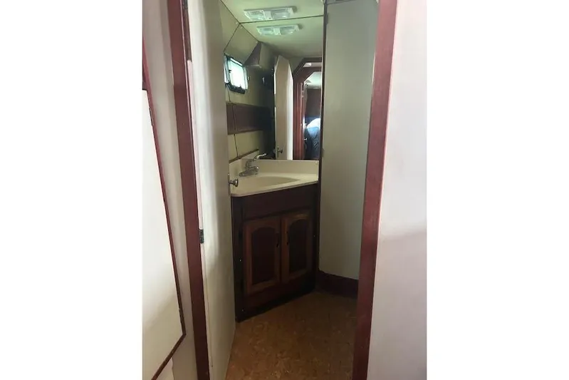 Liahona Yacht Photos Pics Interior of a 1985 Custom model 60, featuring a compact bathroom with a sink and mirror.