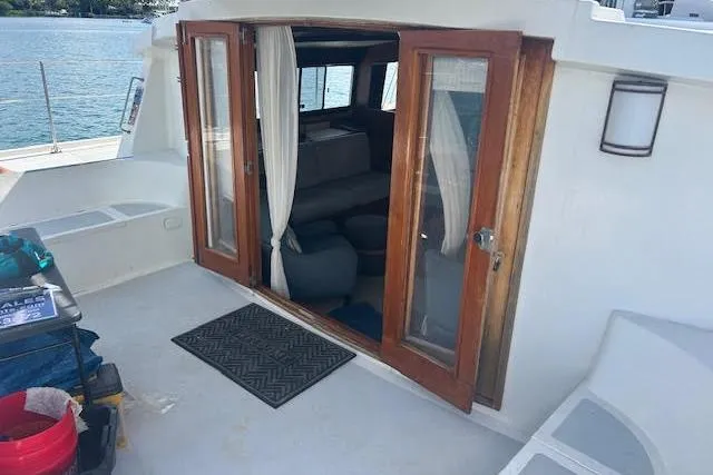 Liahona Yacht Photos Pics Custom 1985 model 60 boat with wooden doors, interior seating, and waterfront view.
