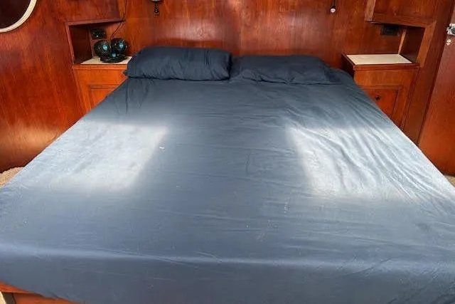 Liahona Yacht Photos Pics Cozy cabin bed with dark bedding in a 1985 Custom model 60 boat interior.