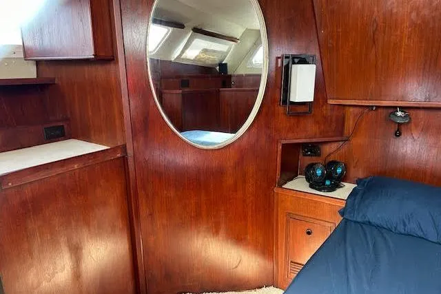Liahona Yacht Photos Pics Wood-paneled cabin interior with round mirror, Custom 60 model, 1985.