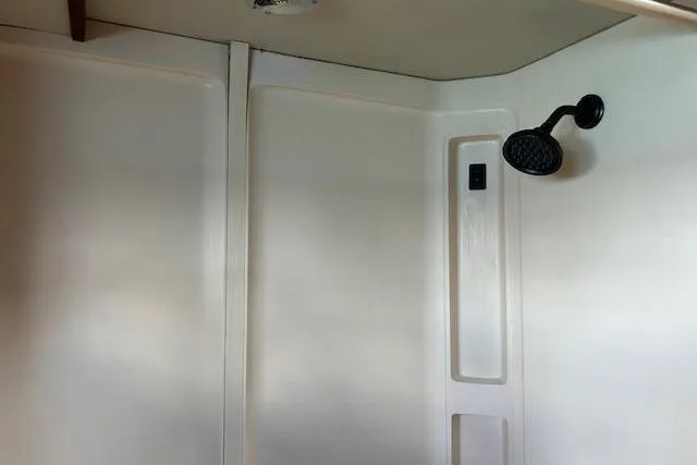 Liahona Yacht Photos Pics Shower interior of a 1985 Custom model 60 with a black showerhead.