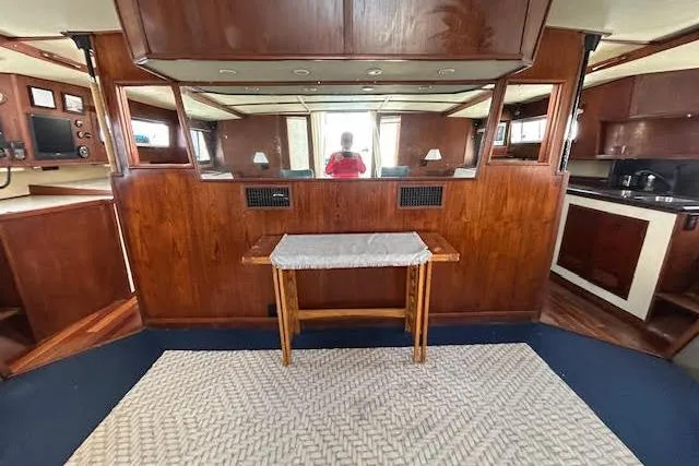 Liahona Yacht Photos Pics Interior of a 1985 Custom Model 60 yacht with wood paneling and a small table.