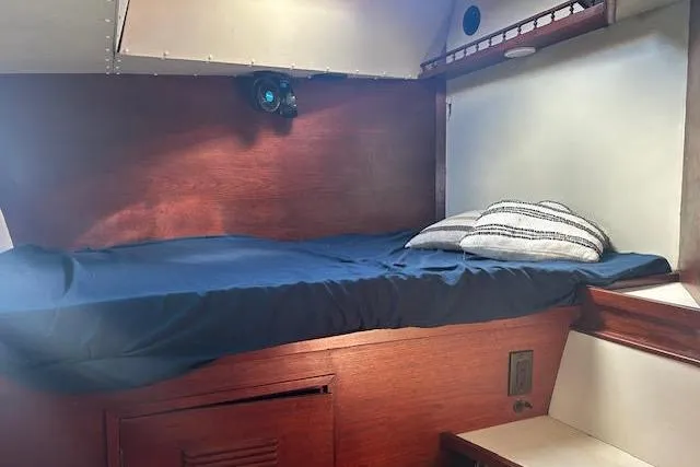 Liahona Yacht Photos Pics Cozy cabin bed in 1985 Custom model 60 boat with blue bedding and pillows.