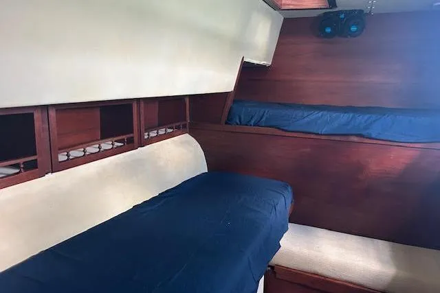 Liahona Yacht Photos Pics Interior of 1985 Custom 60 boat with wooden bunks and blue bedding.