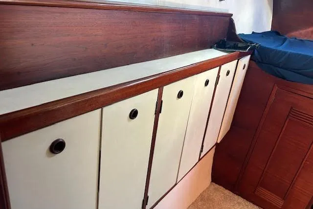 Liahona Yacht Photos Pics Wooden interior cabinets in a 1985 Custom 60 model, featuring white doors and circular handles.