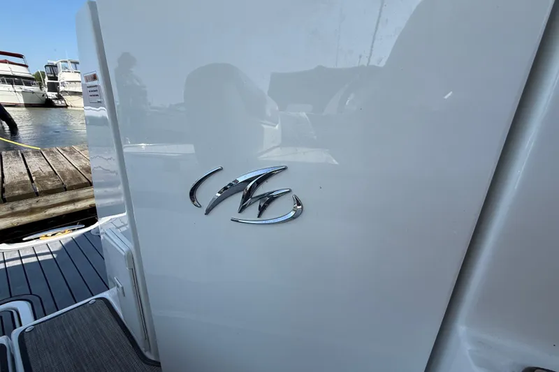  Yacht Photos Pics 2018 Monterey 355 Sport Yacht emblem on white surface, docked near wooden pier.