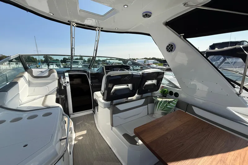  Yacht Photos Pics 2018 Monterey 355 Sport Yacht interior with seating, table, and helm, docked at marina.