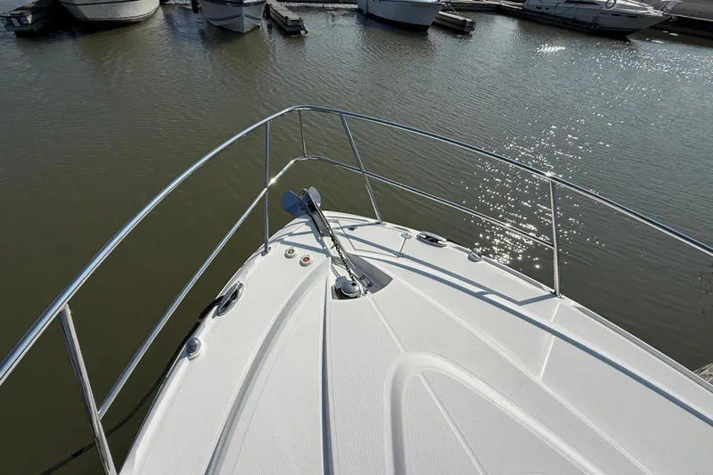  Yacht Photos Pics 2018 Monterey 355 Sport Yacht bow view at marina, with calm water and docked boats.