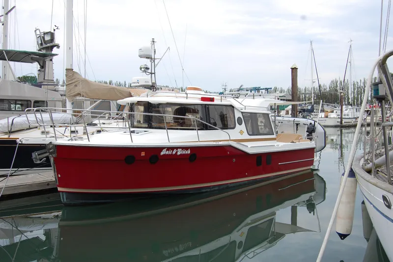  Yacht Photos Pics 2018 Ranger Tugs R29 boat docked in marina, featuring a red hull and white cabin.