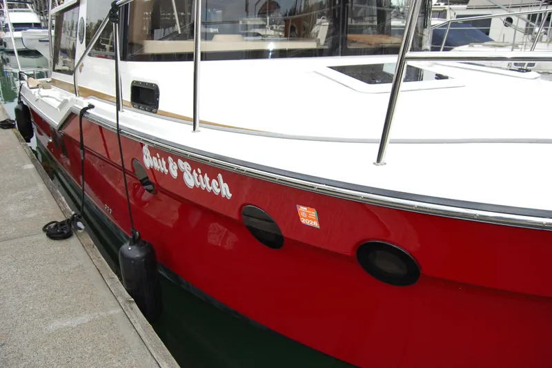  Yacht Photos Pics 2018 Ranger Tugs R29 boat docked, featuring a red hull and white deck.