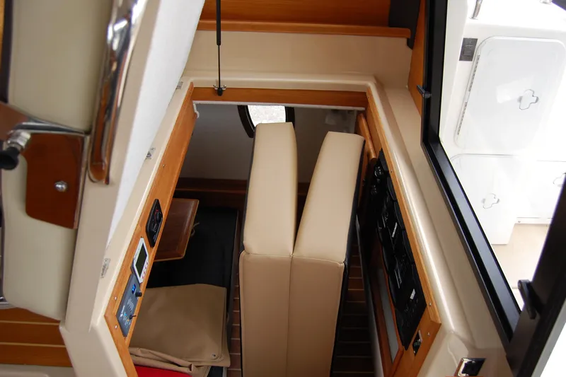  Yacht Photos Pics Interior view of 2018 Ranger Tugs R29 boat, featuring beige seating and control panels.