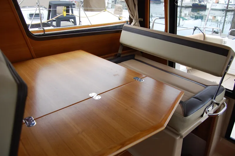  Yacht Photos Pics Interior of 2018 Ranger Tugs R29 with wooden table and cushioned seating.