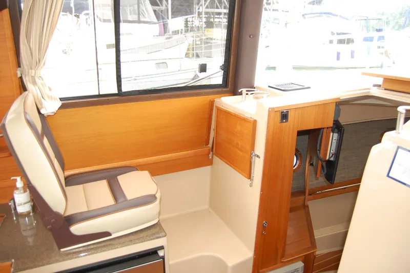  Yacht Photos Pics Interior of 2018 Ranger Tugs R29 boat, featuring seating and wooden cabinetry.