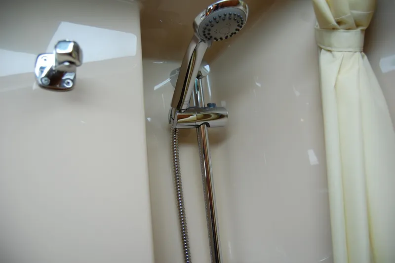  Yacht Photos Pics Shower area in 2018 Ranger Tugs R29 boat, featuring chrome fixtures and cream curtain.