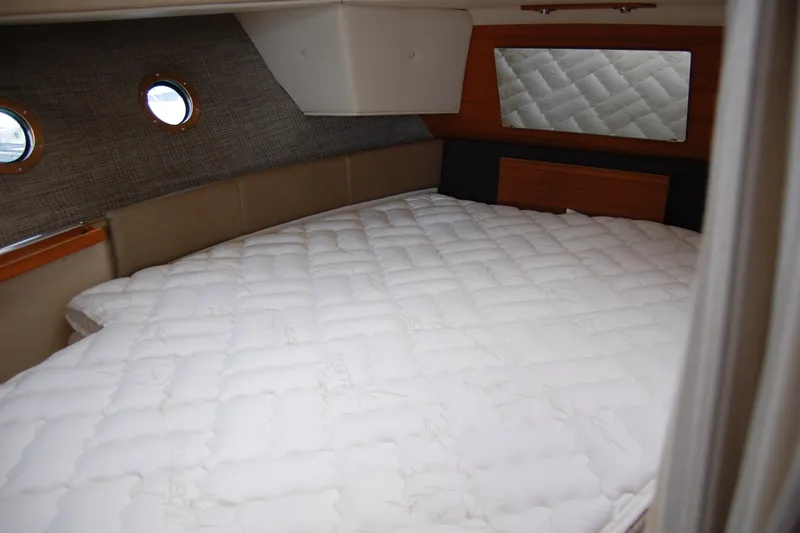  Yacht Photos Pics Cozy cabin interior of 2018 Ranger Tugs R29 with quilted bedding and porthole windows.