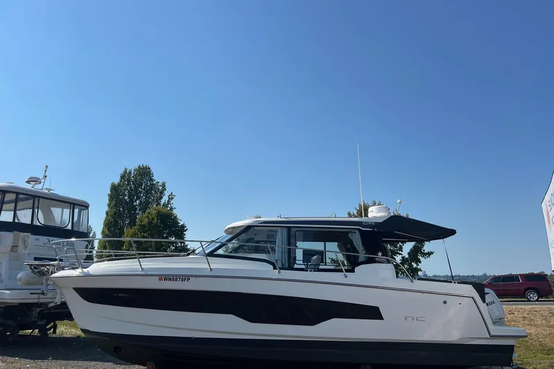  Yacht Photos Pics 2023 Jeanneau NC Weekender 1095 boat on display under clear blue sky.