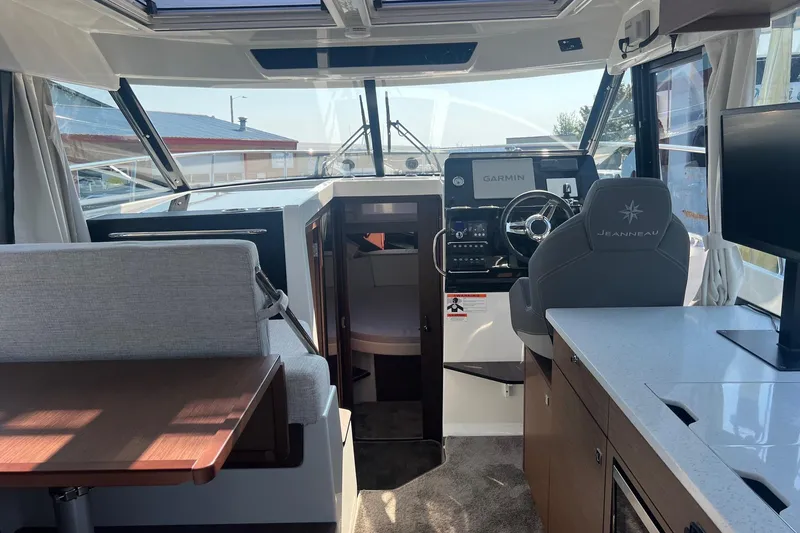  Yacht Photos Pics Interior of 2023 Jeanneau NC Weekender 1095, featuring helm, seating, and modern amenities.