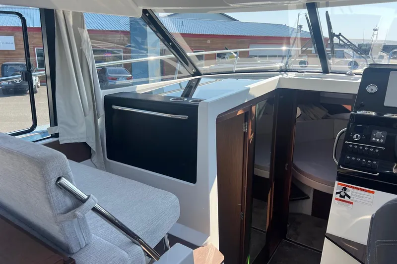  Yacht Photos Pics 2023 Jeanneau NC Weekender 1095 interior with helm, seating, and cabin view.