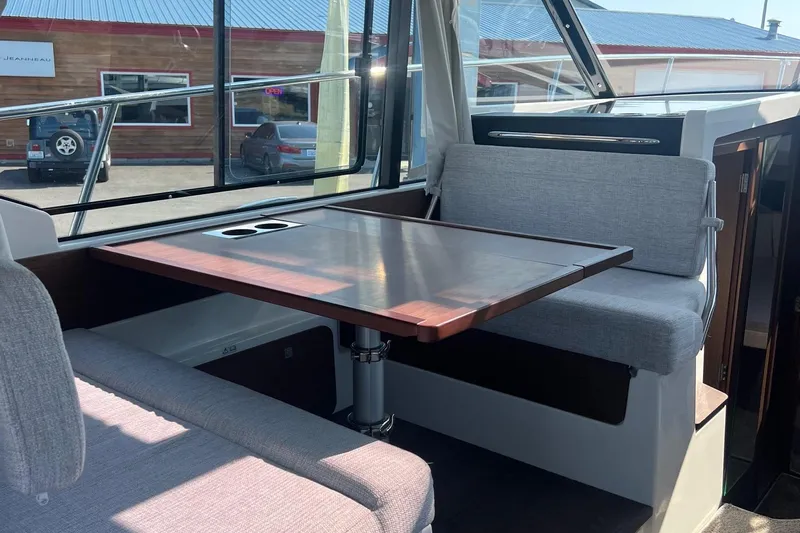  Yacht Photos Pics Interior of 2023 Jeanneau NC Weekender 1095, featuring a cozy dining area with cushioned seating.