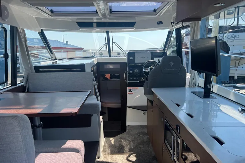  Yacht Photos Pics Interior of 2023 Jeanneau NC Weekender 1095, featuring helm, seating, and modern amenities.