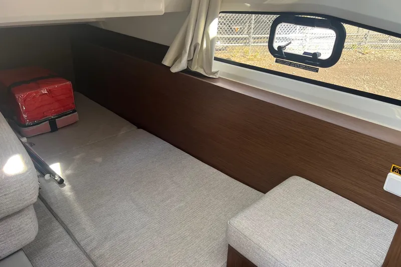  Yacht Photos Pics 2023 Jeanneau NC Weekender 1095 interior cabin with window and seating area.