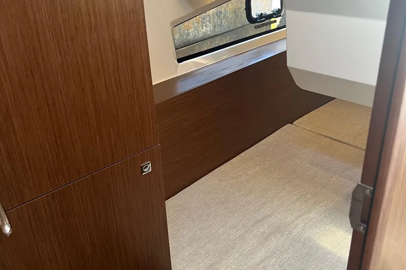  Yacht Photos Pics Interior cabin of 2023 Jeanneau NC Weekender 1095 with wood finish and window.