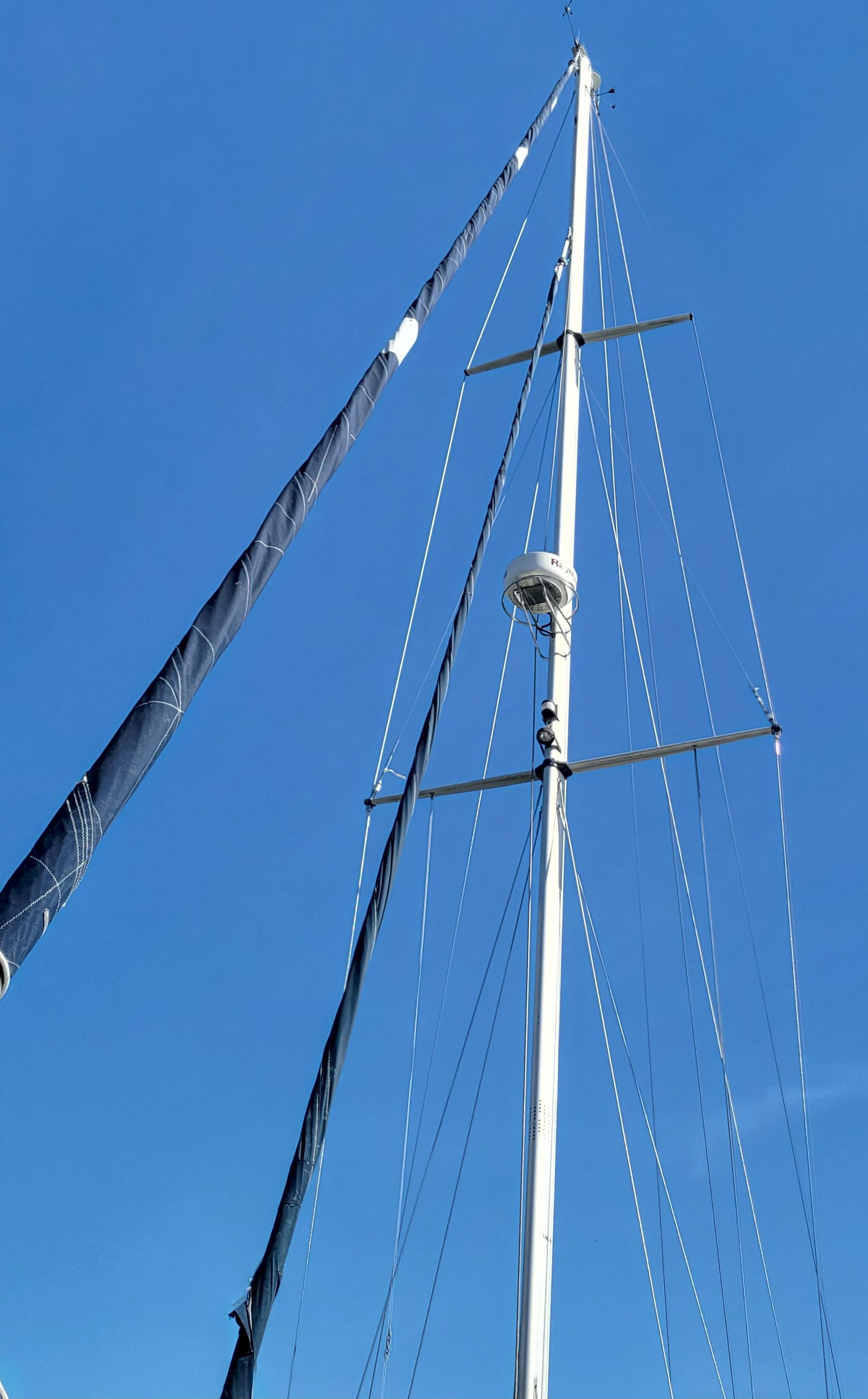 Tall mast of 2003 Caliber 40 LRC SE sailboat against clear blue sky.