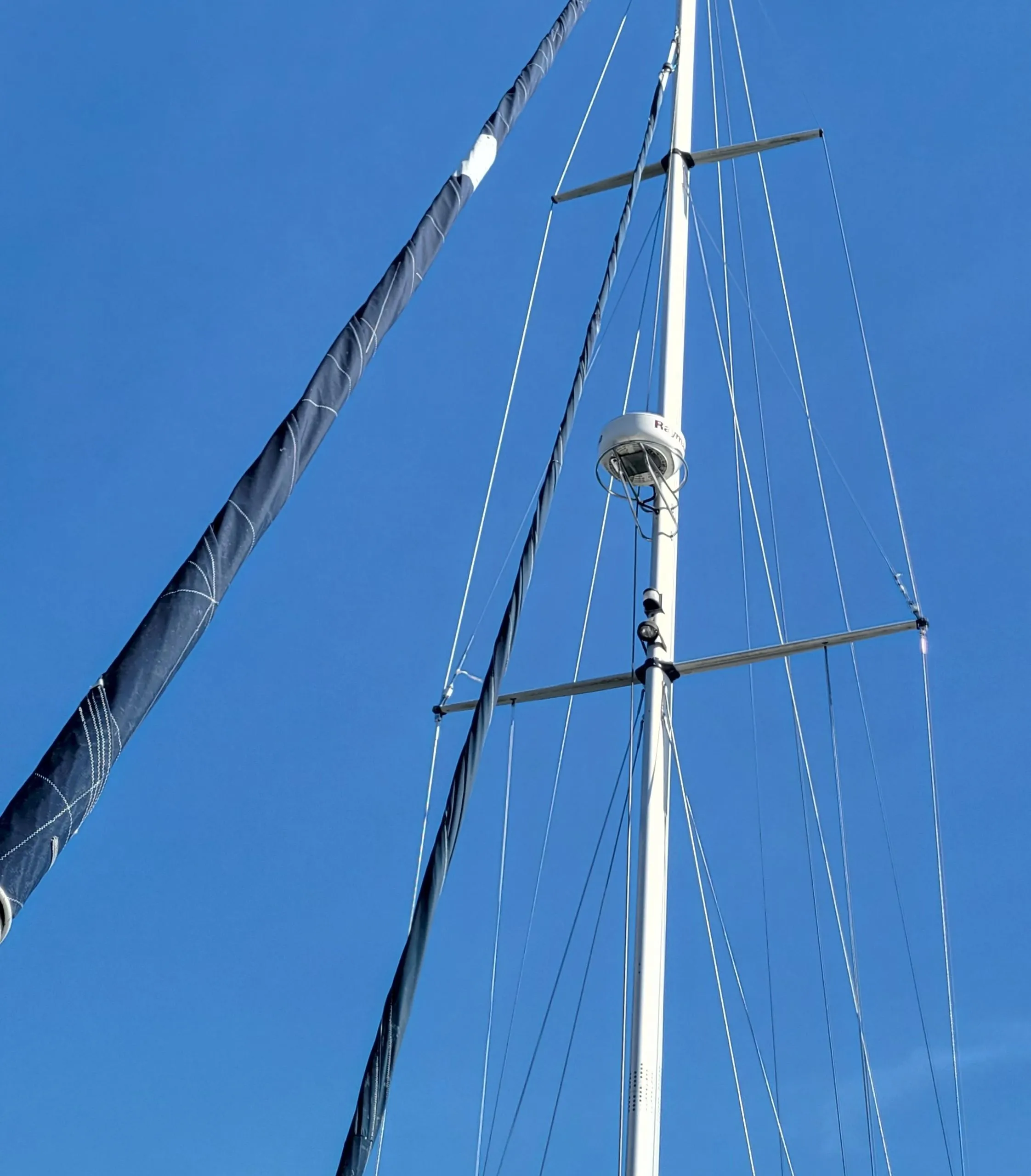 Tall mast of 2003 Caliber 40 LRC SE sailboat against clear blue sky.