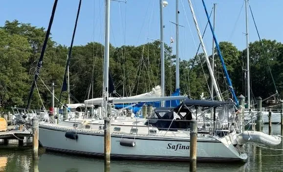 Sailboat Caliber 40 LRC SE 2003 docked at marina with trees in background.