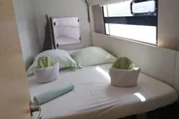 Cozy cabin interior of 2018 Nautitech 40 Open catamaran with neatly arranged bed linens.