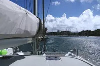 Nautitech 40 Open 2018 sailing in sunny marina with blue sky and clouds.