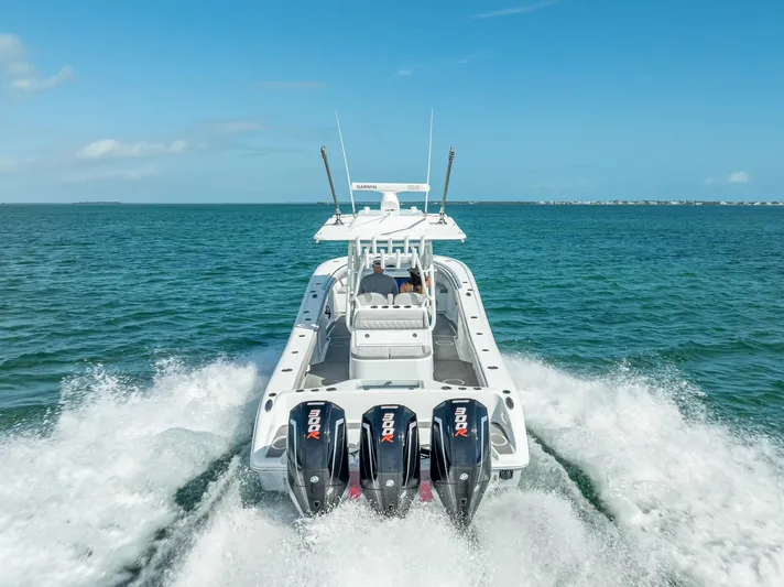  Yacht Photos Pics 2020 Yellowfin 34 boat cruising on open water with triple outboard engines.